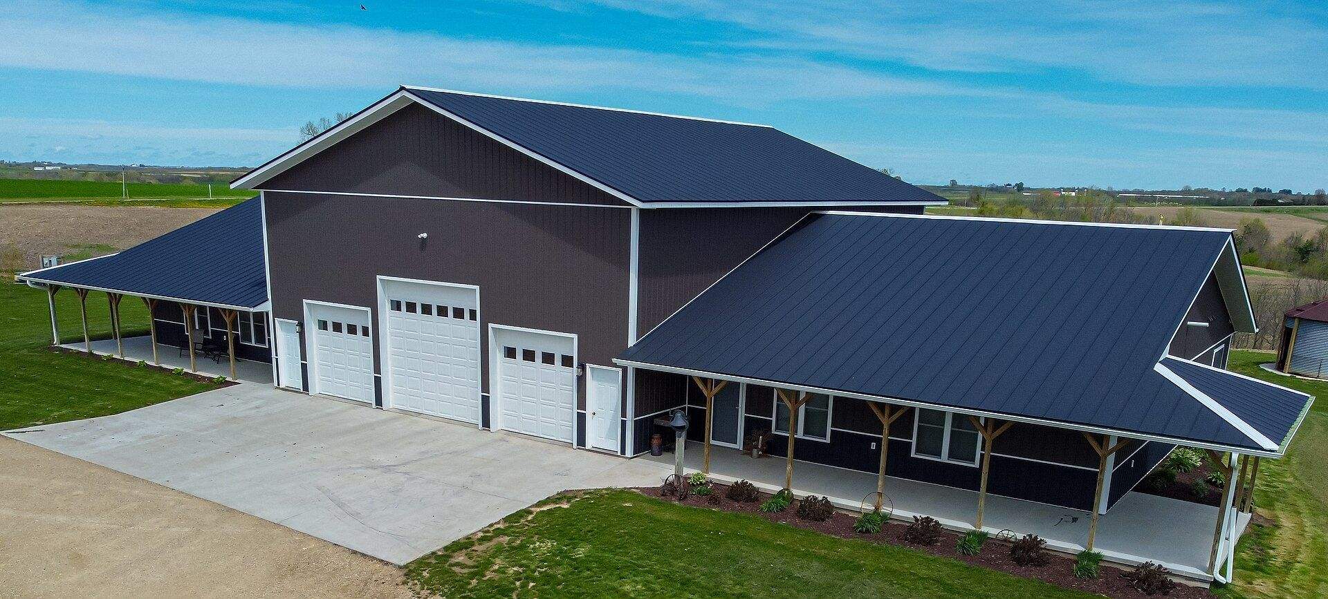 Gray steel-sided home with a metal roof and wraparound porch